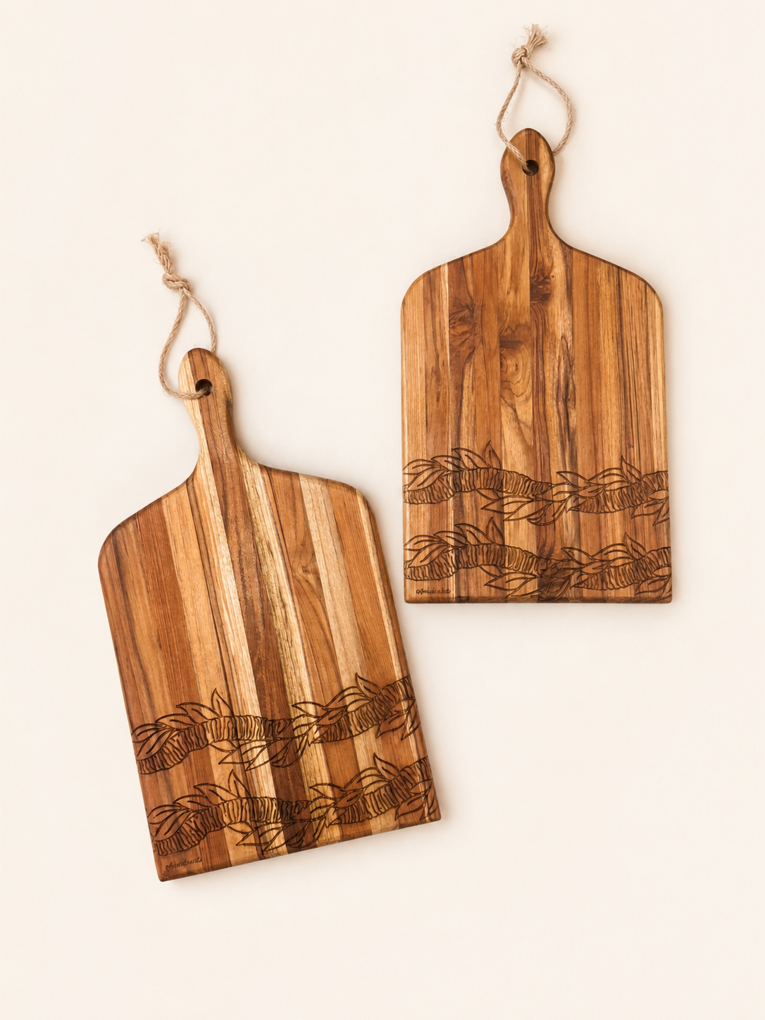 Two wooden serving boards with engraved wheat patterns and natural wood grain, each with a small hanging loop, shown on a light cream background.